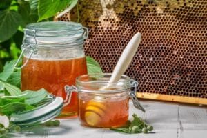 Closeup of honey in a jar and honeycomb